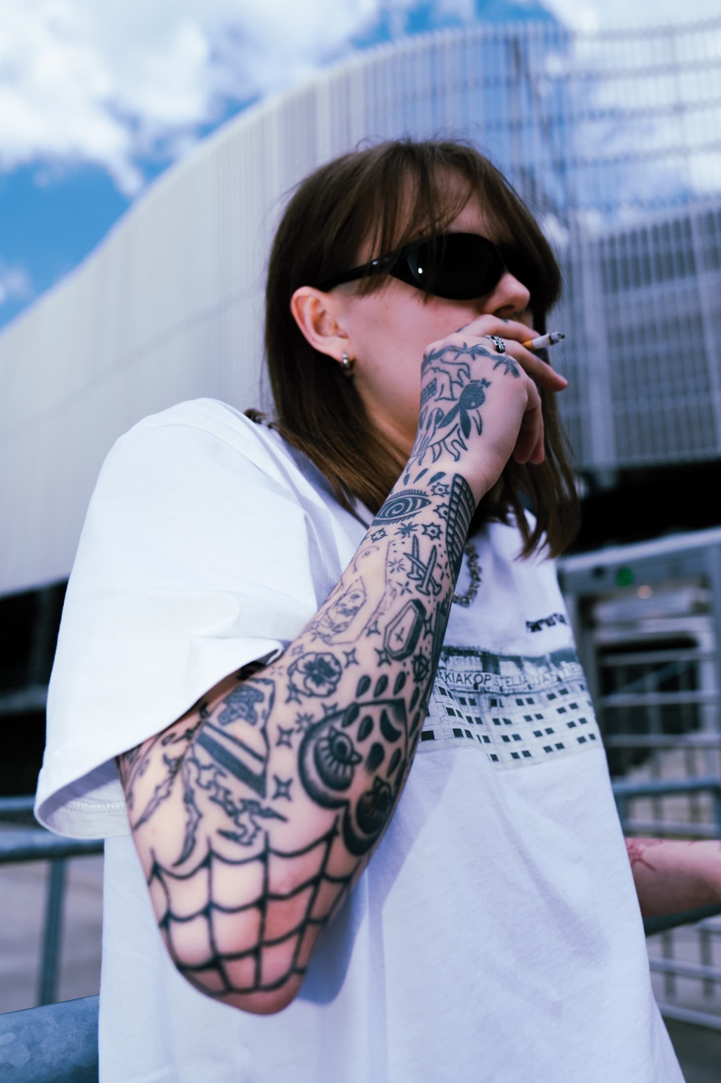 Mid-drag at the stadium rail – full blackwork sleeve, spiderweb elbow.