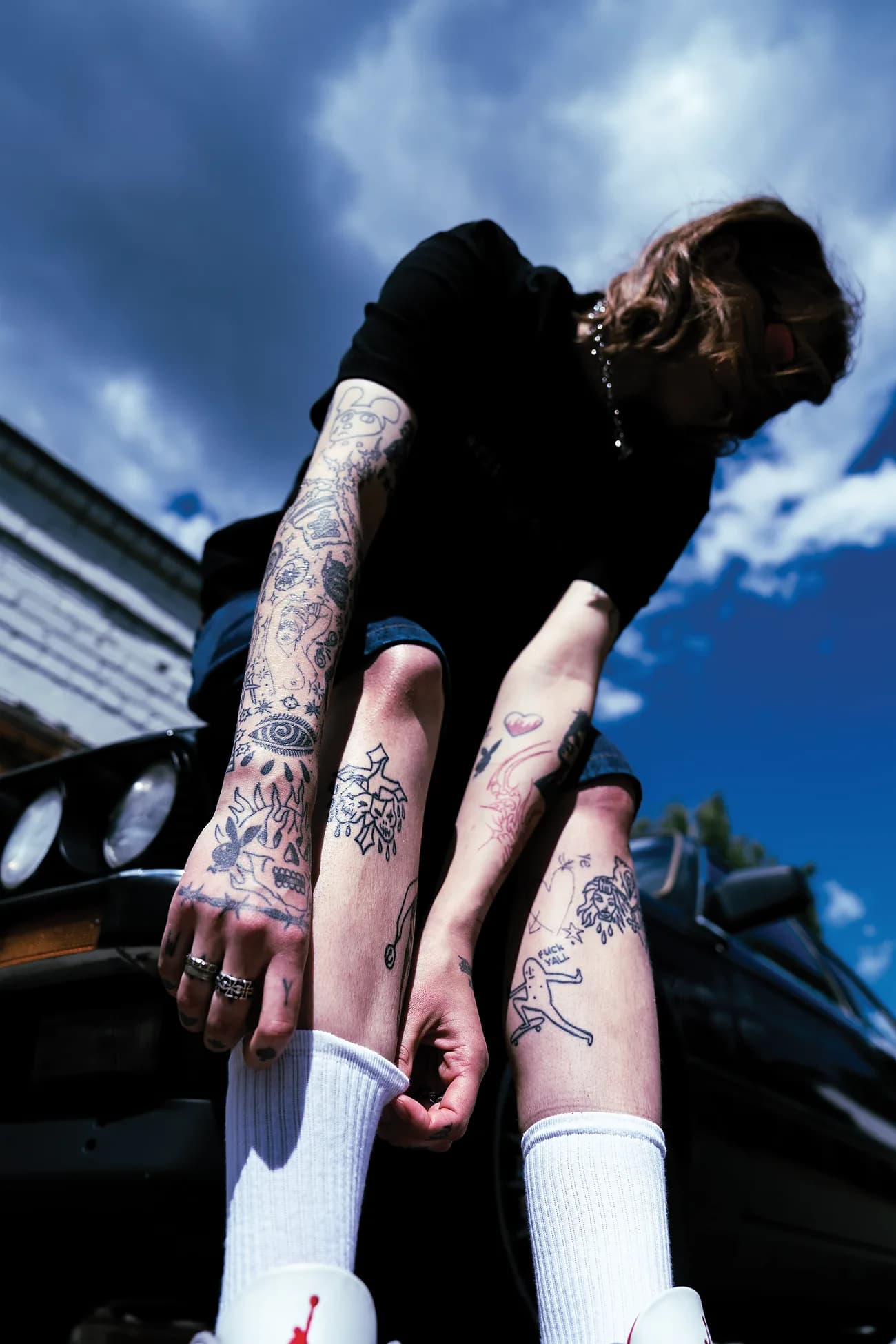 Leaning off the black E30 hood – healed linework down both arms and shins.